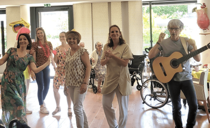 des personnes souriantes dans une salle avec une guitare