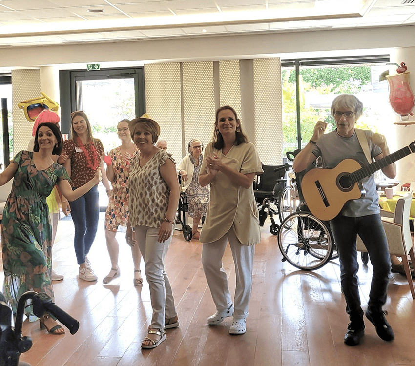 des personnes souriantes dans une salle avec une guitare